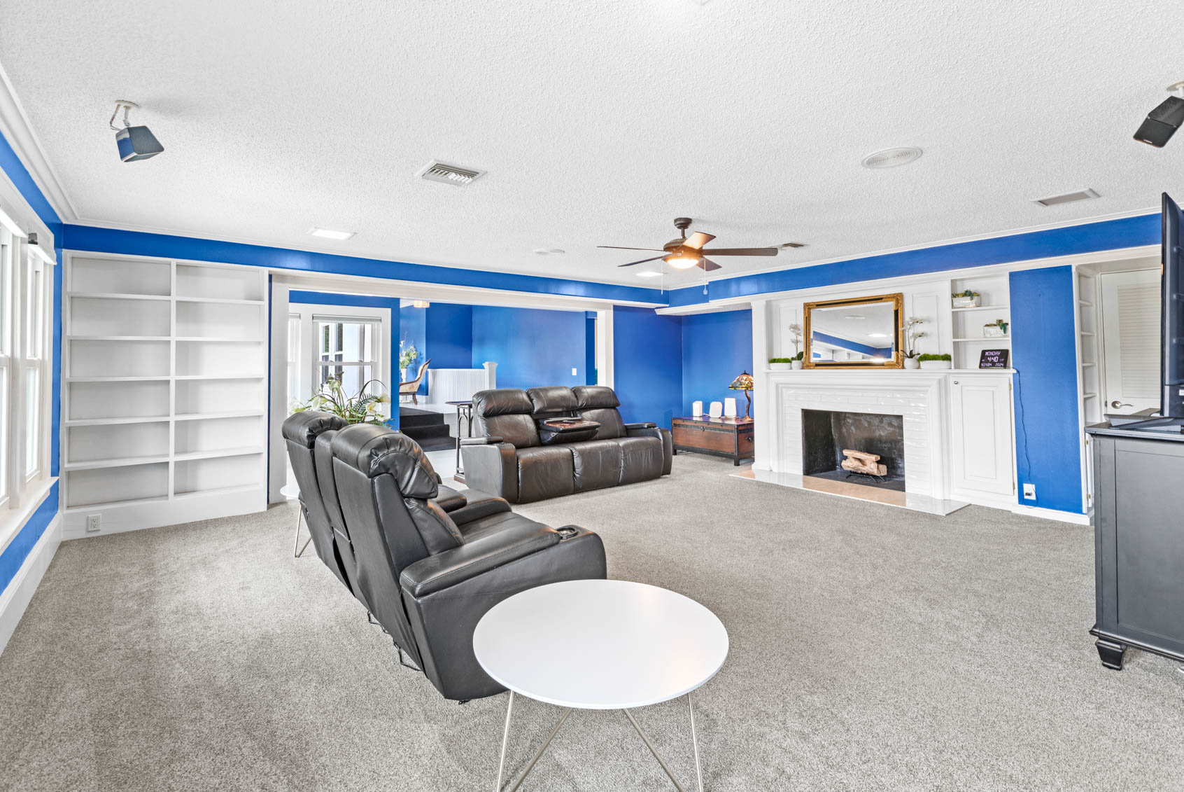 family room with blue walls and black couches